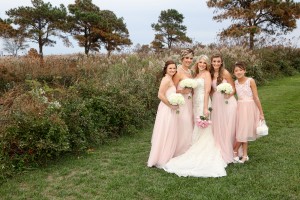 bride posing with bridesmaids on golf green