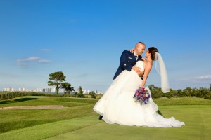 bride and groom posing on golf green