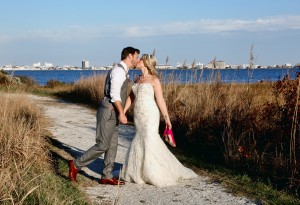 bride and groom kissing with ocean city in background