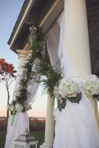 close up of pillars with flowers and curtains