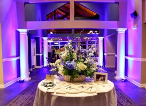 wedding table at entrance with flowers and picture