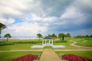 gazebo with white chairs on golf course with bay in background
